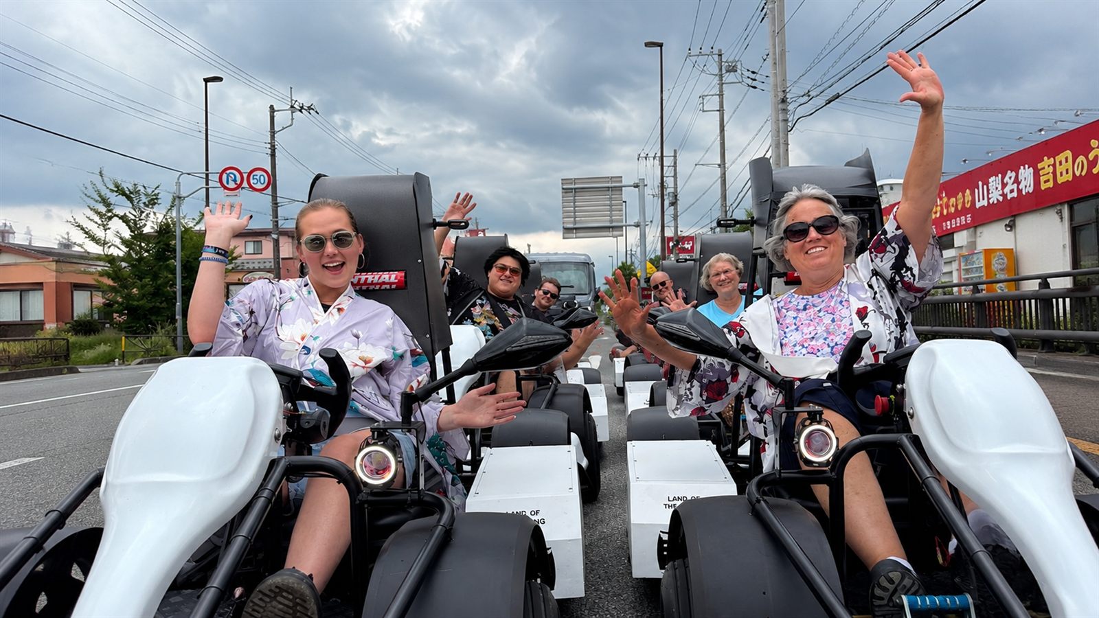Guests in costume waving from their electric go-karts